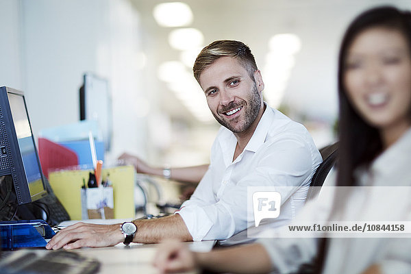 Smiling businessman at computer in office