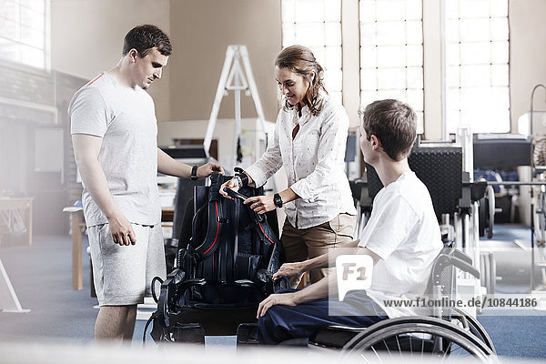 Physiotherapeuten mit Mann im Rollstuhl