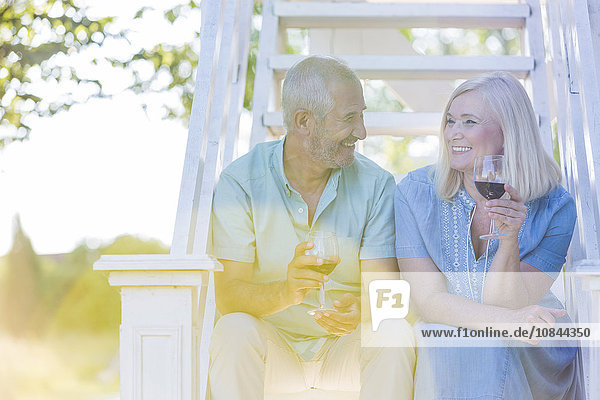 Seniorenpaar trinkt Wein auf der Sommertreppe