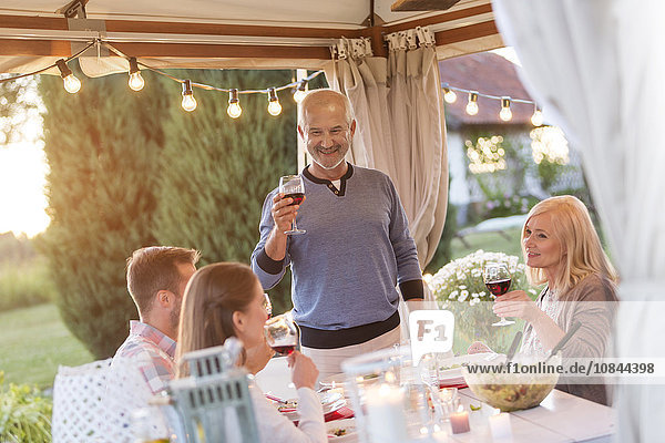 Senior Mann Toast Familie mit Rotwein auf der Terrasse Tisch