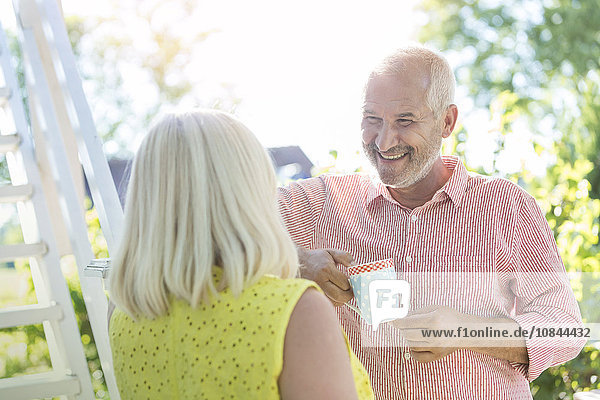 Lächelndes Seniorenpaar beim Kaffeetrinken im Freien