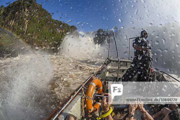 Touristen fahren mit einem Flussboot zum Fuße der Fälle  Nationalpark Iguazu Falls  UNESCO-Weltkulturerbe  Misiones  Argentinien  Südamerika