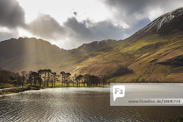 Shafts of light break through clouds to illuminate the fells in winter Buttermere Lake District National Park Cumbria England United Kingdom Europe