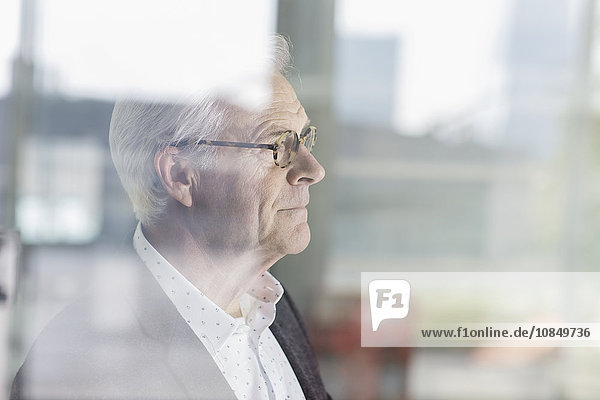 Pensive senior businessman looking out office window