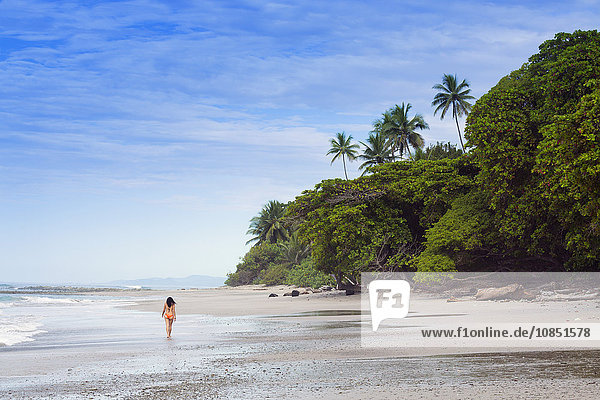 Eine junge Frau spaziert am Strand von Manzanillo in Santa Teresa  Halbinsel Nicoya  Puntarenas  Costa Rica  Mittelamerika