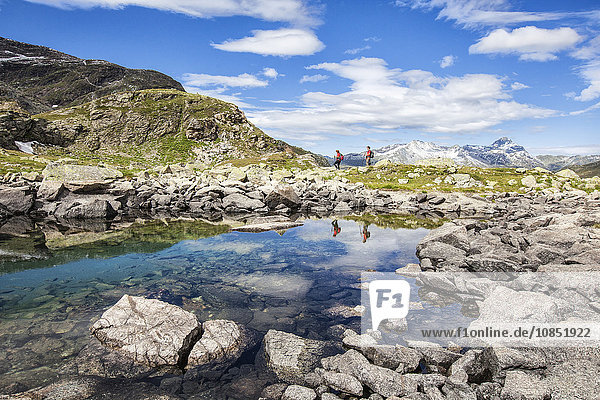 Hikers admire the view at Lake Grevasalvas  Engadine  Canton of Grisons (Graubunden)  Switzerland  Europe