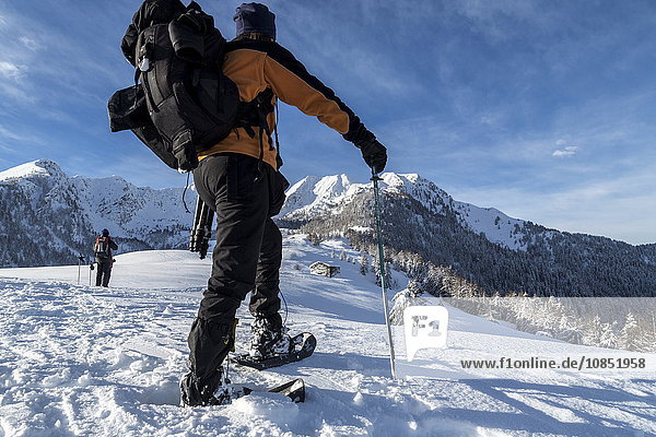 Snowshoe hiker walking in the snowy landscape  Gerola Valley  Valtellina  Orobie Alps  Lombardy  Italy  Europe