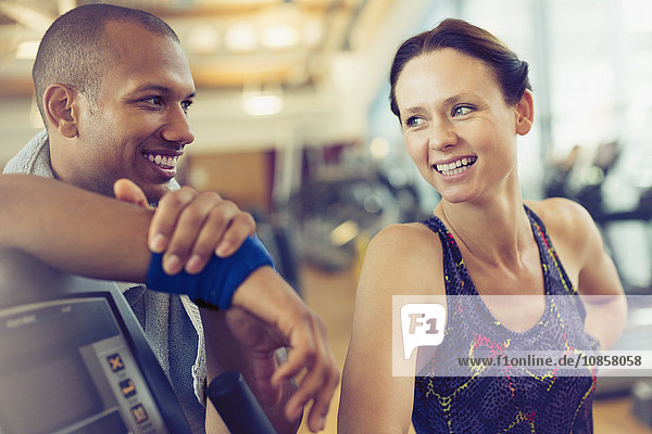 Lächelnder Mann und Frau  die sich im Fitnessstudio ausruhen