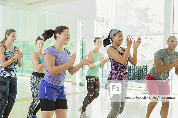 Smiling students clapping in aerobics class