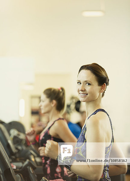 Portrait lächelnde Frau beim Joggen auf dem Laufband im Fitnessstudio