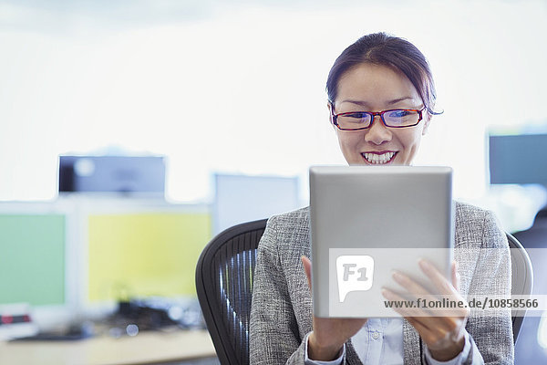 Lächelnde Geschäftsfrau mit digitalem Tablett im Büro