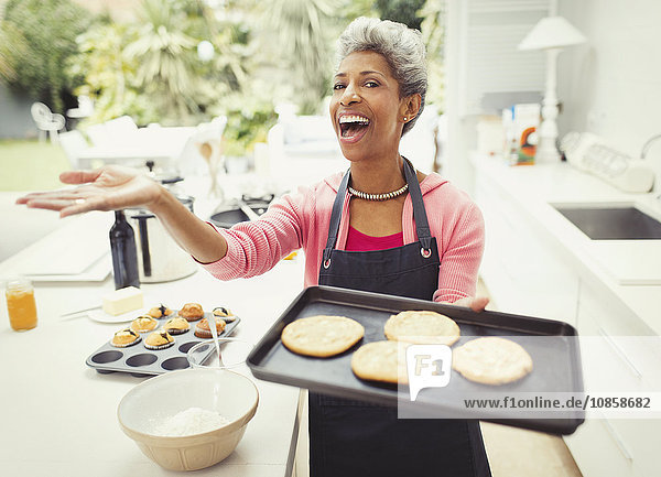 Portrait begeisterte reife Frau beim Backen von Keksen und Küche
