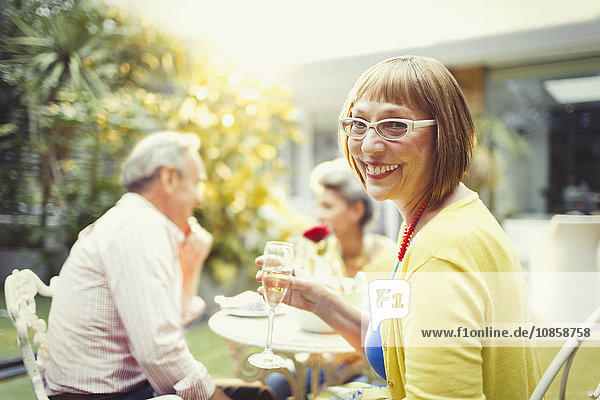 Portrait lächelnde Frau trinkt Champagner auf der Gartenparty