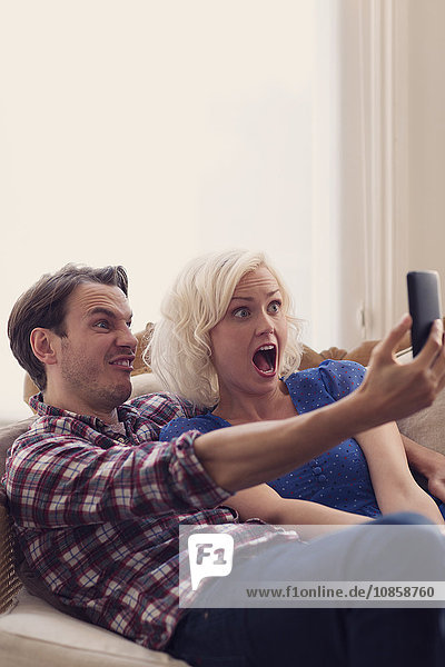 Playful couple making faces taking selfie