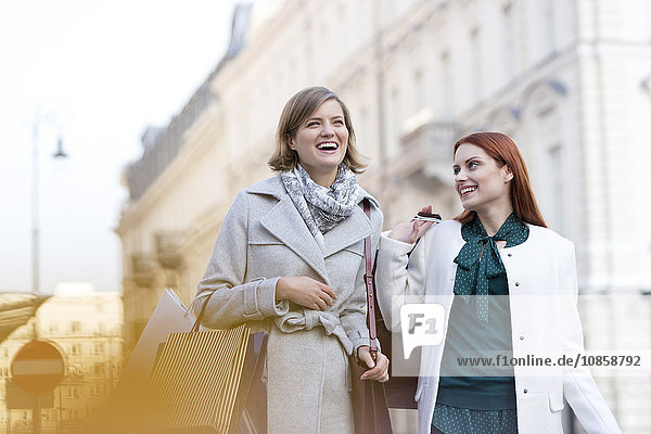 Lächelnde Frauen mit Einkaufstaschen in der Stadt
