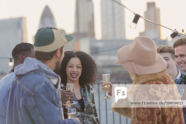 Young adult friends drinking champagne at rooftop party