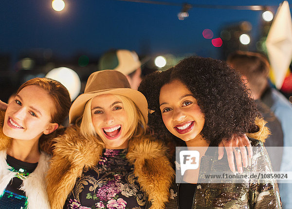 Portrait lächelnde junge Frauen genießen Dachparty
