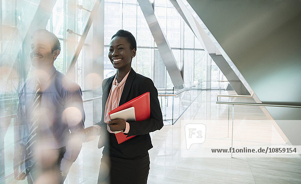 Smiling corporate businesswoman in modern office lobby