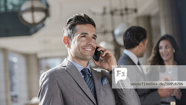 Lächelnder Geschäftsmann im Gespräch mit dem Handy