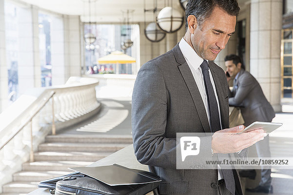 Corporate businessman using digital tablet outdoors
