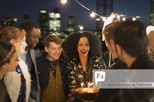 Young friends celebrating birthday at rooftop party