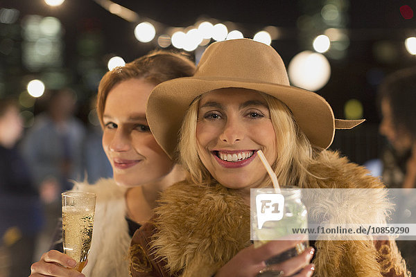 Portrait lächelnde junge Frauen trinken Cocktails auf der Party
