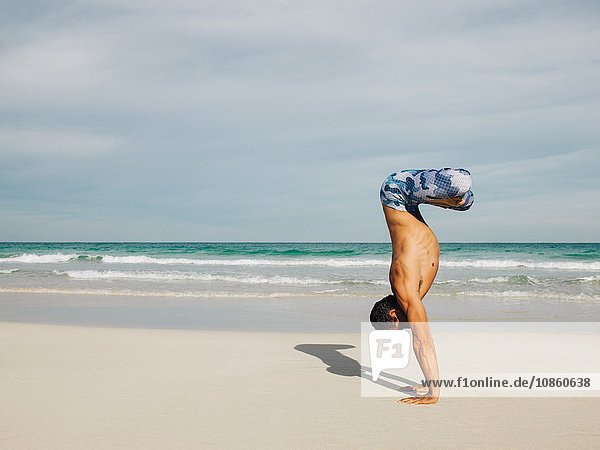 Mature man doing handstand on beach South Pointe Park South Beach Miami Florida USA