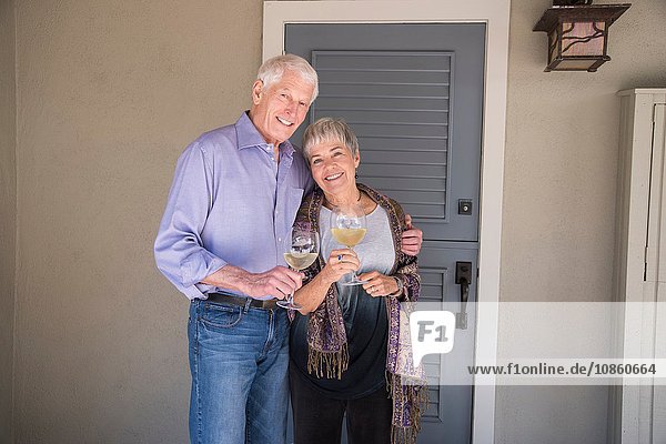 Porträt eines älteren Ehepaares  ein Glas Wein haltend  lächelnd