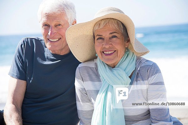 Älteres Ehepaar entspannt am Strand und lächelt