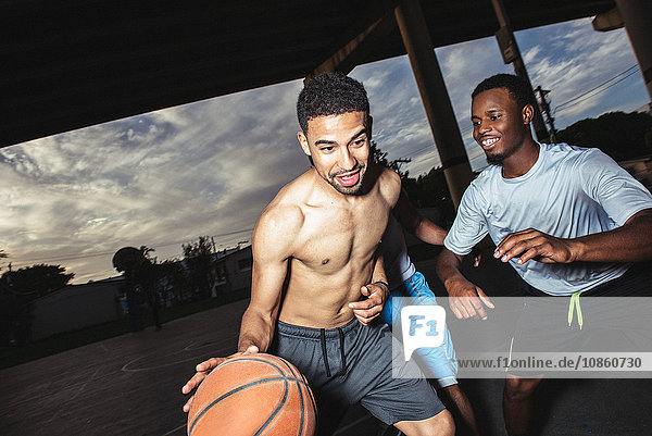 Young men playing basket ball smiling
