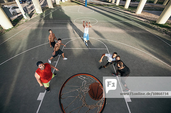 High angle view of men on basketball court watching basketball going through basketball hoop