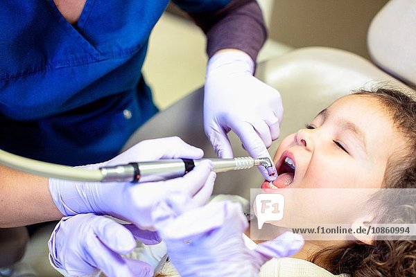 Schrägansicht eines Mädchens auf einem Zahnarztstuhl bei einer zahnärztlichen Untersuchung