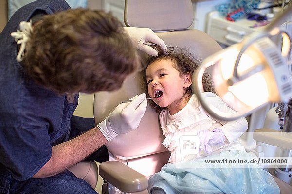 Zahnarzt gebendes Mädchen im Zahnarztstuhl zahnärztliche Untersuchung