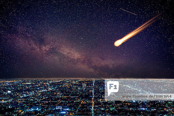 Meteor am Nachthimmel fällt über beleuchtete Stadtlandschaft