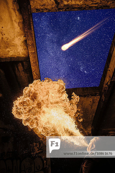 Tiefblick auf den Menschen  der Feuer atmet  Meteor am sternenklaren Nachthimmel