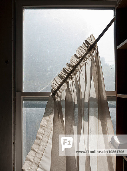 Gardinen  die von einem schmutzigen Schiebefenster fallen