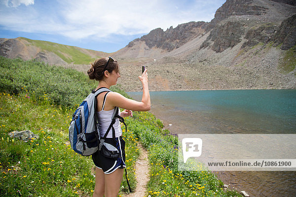 Hiker taking photograph of view  Cathedral Lake  Aspen  Colorado