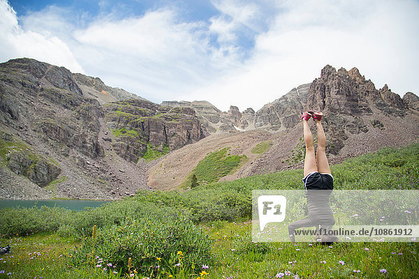 Woman practising yoga on meadow  Cathedral Lake  Aspen  Colorado