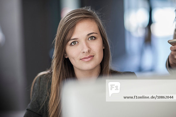 Portrait of young businesswoman sitting at desk
