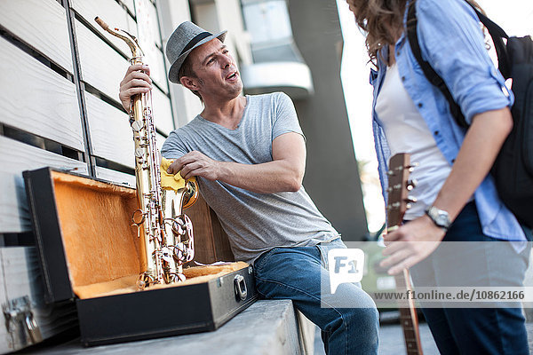 Straßenmusikant putzt Saxophon