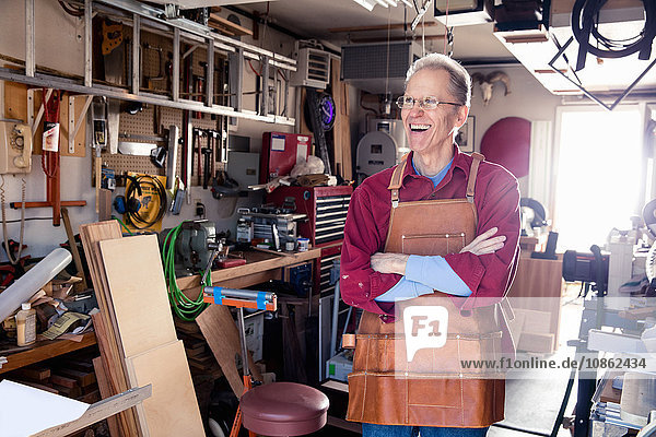 Portrait of happy senior man in his carpentry workshop