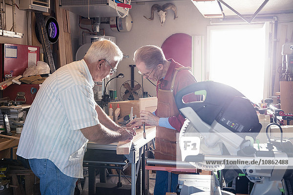 Senior men working with chisel in carpentry workshop