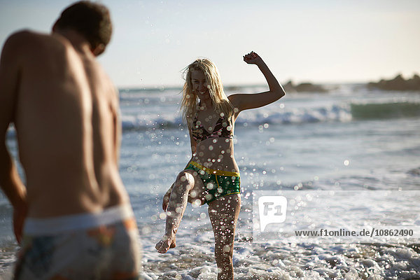Ehepaar am Strand beim Plantschen im Meer