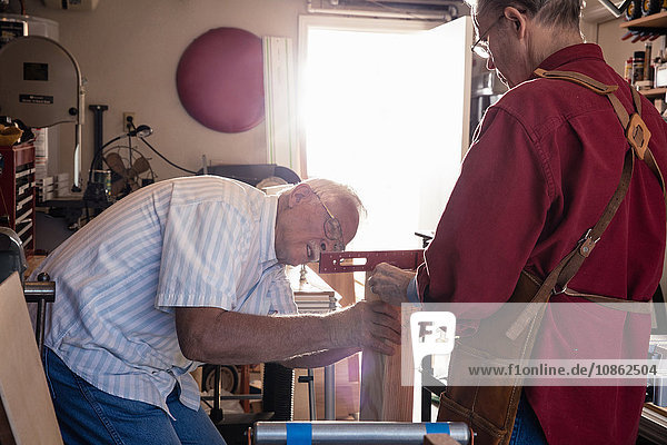 Senior men checking spirit level in carpentry workshop