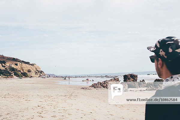 Mann mit Baseballmütze schaut auf den Strand  Crystal Cove State Park  Laguna Beach  Kalifornien  USA