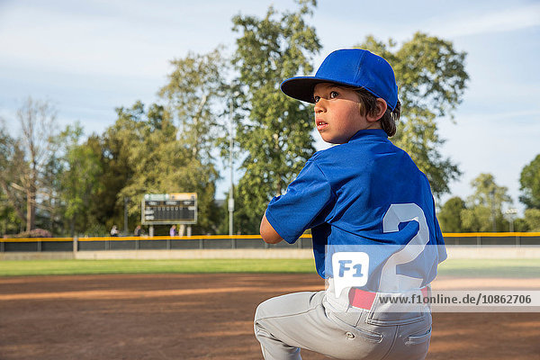 Boy throwing ball at practise on baseball field