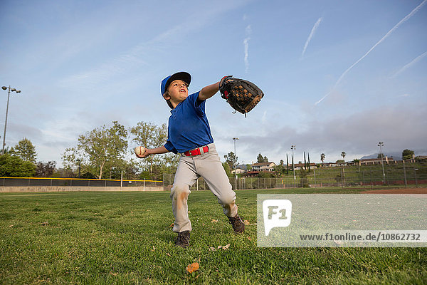 Junge wirft Ball beim Training auf dem Baseballfeld