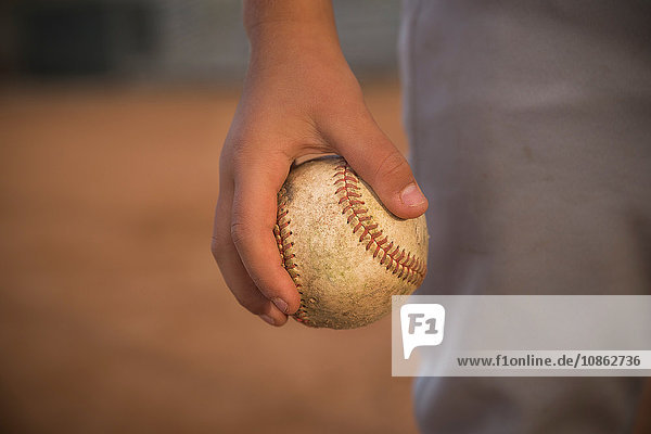 Nahaufnahme der Hand des Jungen  der den Ball beim Baseball-Training in der Hand hält