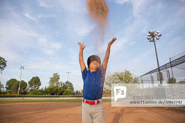 Junge wirft Baseball-Handschuh mitten in die Luft beim Baseball-Training
