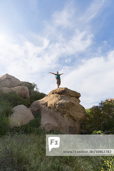 Wanderfrau auf dem Gipfel eines Felsens Arme erhoben